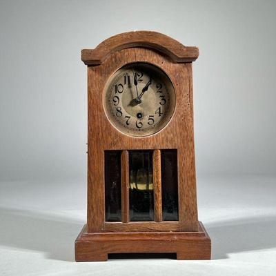 MISSION-STYLE OAK SHELF CLOCK | Likely German, having an oak case with hinged front door with three beveled glass panels before a brass...