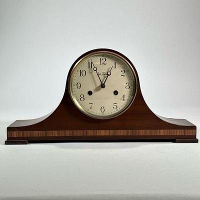 CONTEMPORARY SETH THOMAS MANTEL CLOCK | German Seth Thomas clock in a wood case with faux inlay. - h. 8.25 x w. 18.75 x d. 4.25 in

