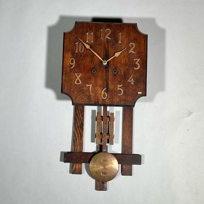 MISSION STYLE WALL CLOCK | Carved wood face with applied copper numeral markers, with mission-style wood and brass pendulum. - h. 26 x w....