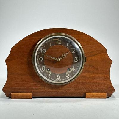 PLYMOUTH SHELF CLOCK | The Plymouth Clock, Thomaston, Conn., in a curved wood case, with Guarantee and Directions fixed inside the back...