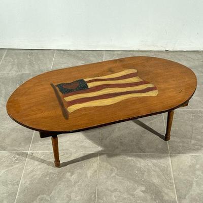 AMERICAN FLAG HEART PAINTED TABLE | Low oval top wood table with painted American flag with heart motif. - h. 16 x l. 47 x d. 24 in

