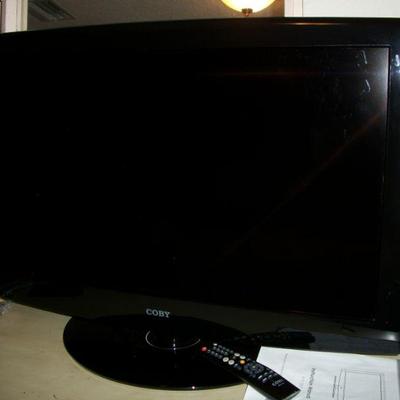 Coby 32in TV with remote and paperwork.