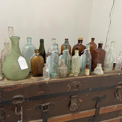 A collection of antique bottles including a green uranium glass Frigidaire decanter and three beer bottles from the 1800s and early 1900s...