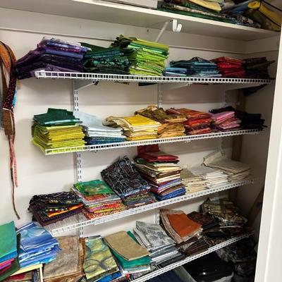 A room full of quilting supplies, fabrics, tools, finished quilted items and more!!