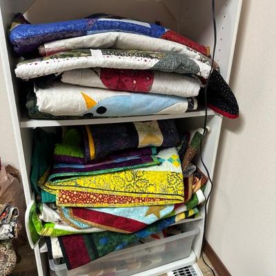 A room full of quilting supplies, fabrics, tools, finished quilted items and more!!