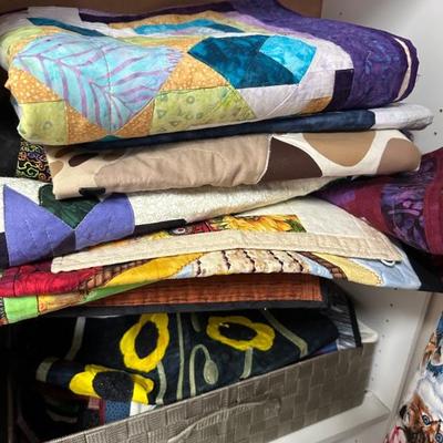 A room full of quilting supplies, fabrics, tools, finished quilted items and more!!
