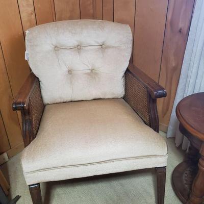 Cozy pair of upholstered armchairs with tufted backs and woven cane sides
