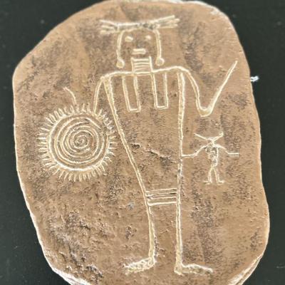 Primitive man holding shield etched in stone
