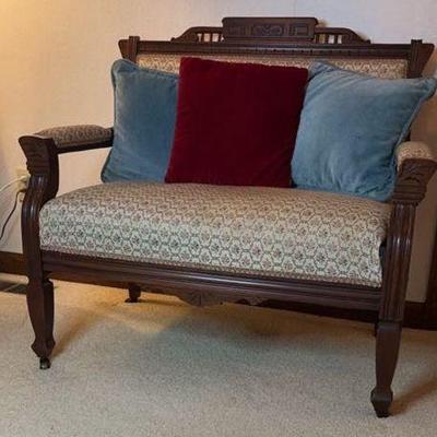 Vintage wood upholstered settee on casters