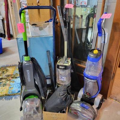 2 Bissell carpet cleaners and a Shark vacuum