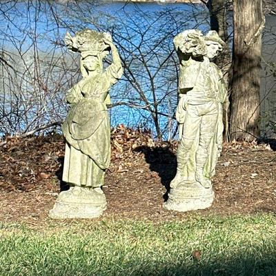(2pc) PAIR CONCRETE GARDEN STATUES | Pair of concrete garden statues depicting figure of a woman with basket of fruit atop her head and a...