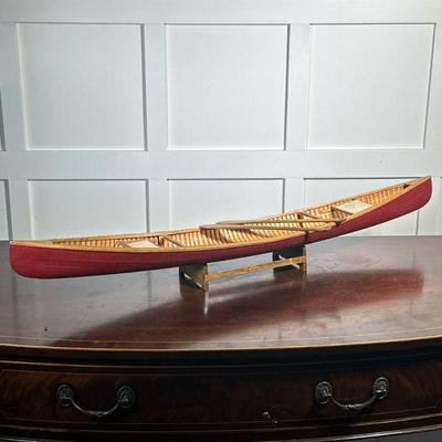 MODEL CANOE | Red painted model canoe with removable seats & two paddles on a wood stand - h. 6 x w. 6.5 x l. 39 in

