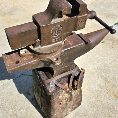 Big vintage Prentiss Bulldog (New York) bench vise. Large, heavy vintage anvil strapped on an old block of wood.