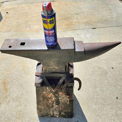 Large, heavy vintage anvil strapped on an old block of wood.