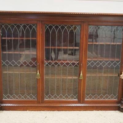 1159	MAHOGANY 3 DOOR LEADED GLASS BOOKCASE W/PINEAPPLE CARVED HALF COLUMNS, ONE PANEL DAMAGED, APPROXIMATELY 17 IN X 77 IN X 55 IN HIGH
