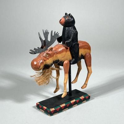 BEAR RIDING MOOSE | Wood carved bear riding a moose on wood stand - h. 10.25 x w. 2.5 x l. 6 in

Contact All Country Estate Sales
