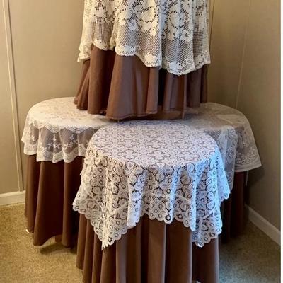 Vintage accent tables set of four with decorative coverings 4 browns, 2 beige and 1 wine colored.