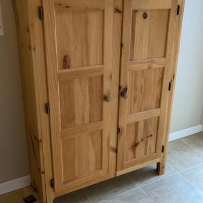 Unfinished wood cabinet with two doors and three shelves.