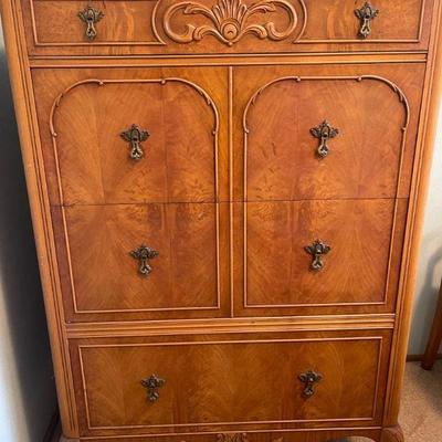 Tall blonde dresser with carved wood detail