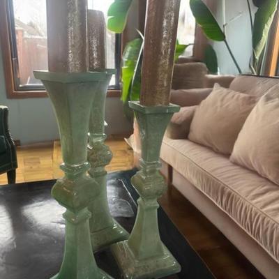 3 tall green candlesticks with candles.