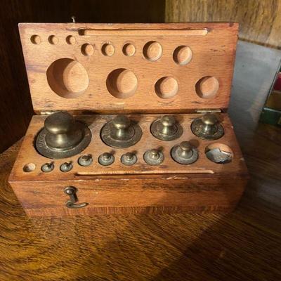 Brass scale weights with wooden storage block
