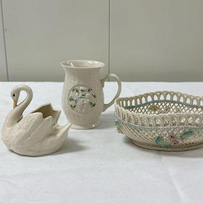 (3pc) Belleek Decor | Belleek snowman mug: 4.5 in. Belleek ceramic basket: 7 in. x 5 in. x 2.5 in. Swan (unmarked): 3 in.

