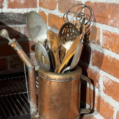 Copper oil can with kitchen utensils