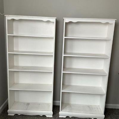 Pair of white wooden bookshelves with decorative trim