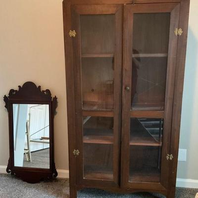 Vintage wooden display cabinet with glass doors ornate wall mirror