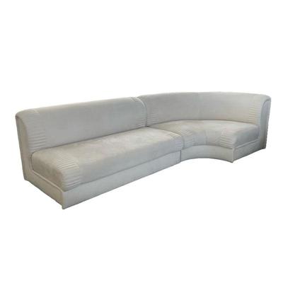 CONTEMPORARY SECTIONAL SOFA | Overall ultra suede creme colored upholstery, two sections including a straight and a curved corner piece,...