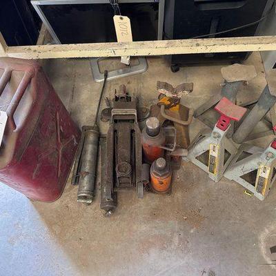 #1010 • Jerry Can, (2) Bottle Jacks, Floor Jack, (5) Jack Stands, and (2) Oil Guns
