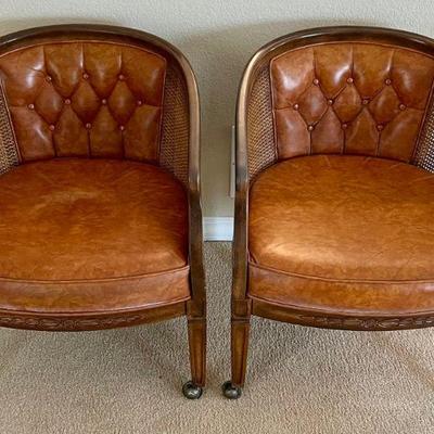 Pair Of Vintage Leather Tufted Barrel Chairs With Cane Sides And Metal Casters