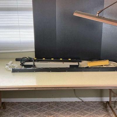 Sturdy work table with adjustable task lamp and power strips