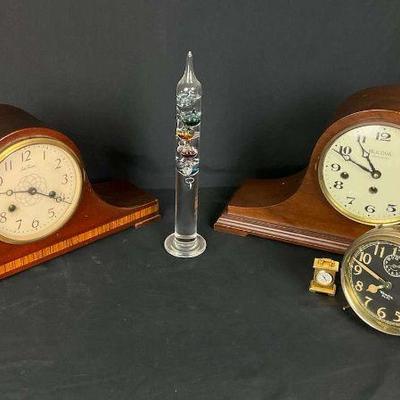 Collection of mantel and vintage clocks with decorative glass accent