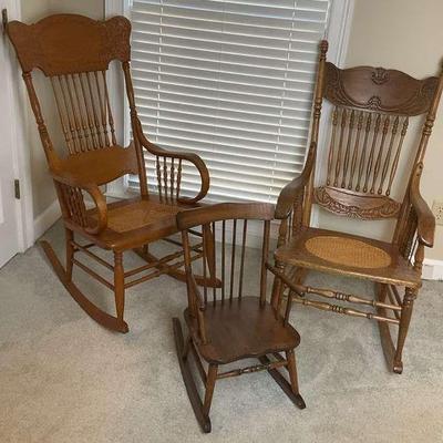 Set of two adult cane seat rocking chairs and one childs rocking chair