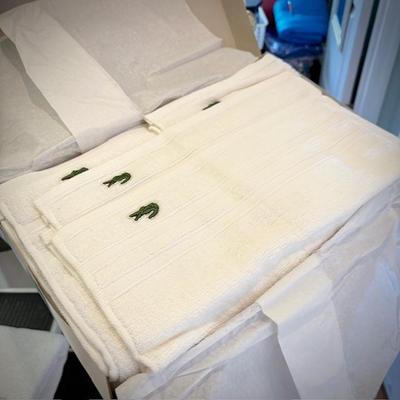 Box of white Lacoste Izon towel set with alligator log
