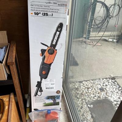 LOTS OF GARDENING TOOLS INCLUDING THIS ELECTRIC CHAIN SAW.
