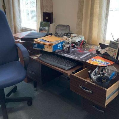 Desk and chair with lots of office supplies