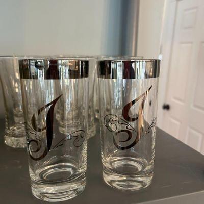 Set of 9 J Silver rimmed glasses. 