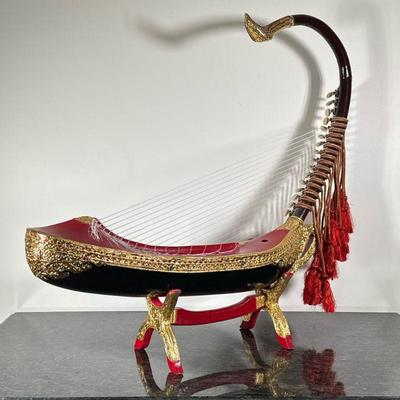 BURMESE SAUNG-GUAK HARP | Burmese Saung-guak harp on stand with gilt decoration. - h. 32.5 x w. 8 x l. 34 in

