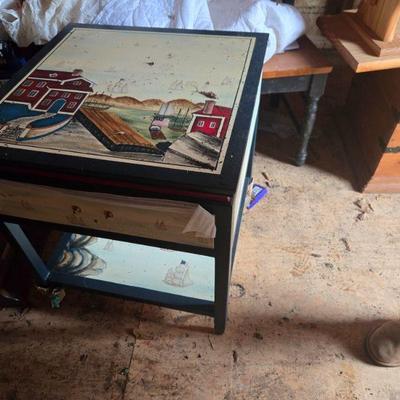 Themed Painted End Table
•	 A beautifully painted end table with a nautical theme. Featuring a coastal scene with houses, boats, and...