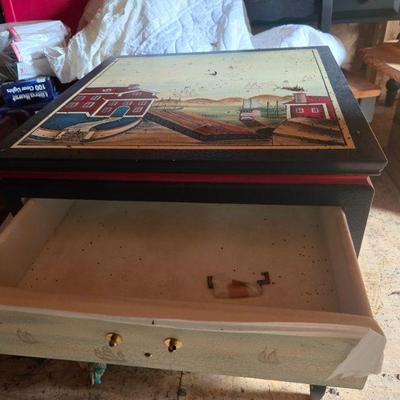 Themed Painted End Table
•	 A beautifully painted end table with a nautical theme. Featuring a coastal scene with houses, boats, and...