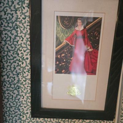Vintage Framed Artwork
- This framed print captures the essence of vintage glamour with a stunning woman in a red dress, poised and...