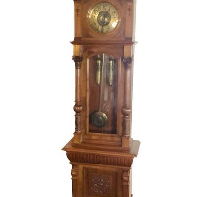JAKA820 German Grandfather Clock	Grandfather clock with carved Corinthian trim posts, ornate rose pattern on clock face/pendulum....
