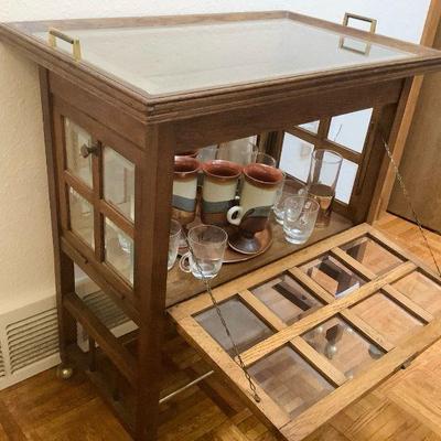 JAKA809 Vintage Display Cabinet with Mugs And Etched Glassware	Cabinet is on wheels for easy mobility and all four sides of cabinet open...