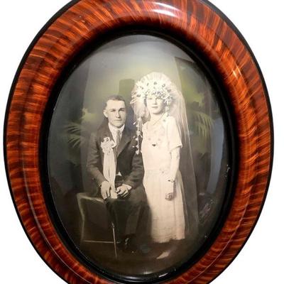 JAKA231 Antique Wedding Photo In Oval Convex Glass, Wood Frame	Antique oval wood frame w/convex glass enclosing a hand-tinted photograph...