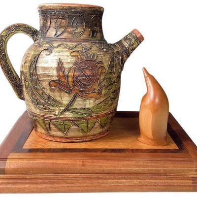 JAKA732 Clay Pottery and Hand Carved Wood Penquin Decor	Ornately hand carved and painted clay pottery pitcher, 9.5"T x 10"W\
