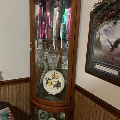Curio Cabinet 
- A well-crafted wooden curio cabinet, featuring a beautiful array of decorative vases, crystal glassware, and a lovely...