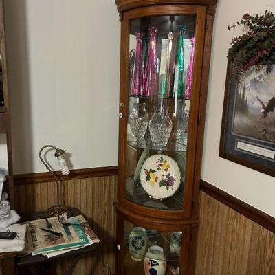 Curio Cabinet 
- A well-crafted wooden curio cabinet, featuring a beautiful array of decorative vases, crystal glassware, and a lovely...