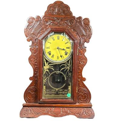 Carved Wood Shelf Clock | Ornate carved wood shelf clock, having a yellow face with Roman numeral markers. - h. 22 x w. 14.25 x d. 4.5 in

